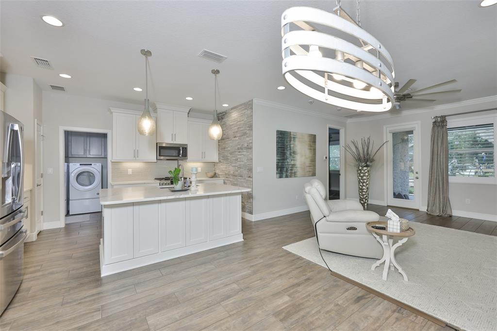 2262 Spring Lake Clearwater, FL 33763 - Photo 6 of 51 a large white kitchen with a large island oven a stove and a chandelier