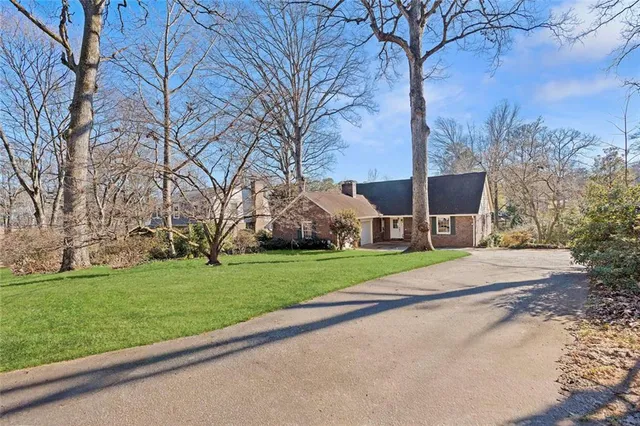 a house view with a garden and trees