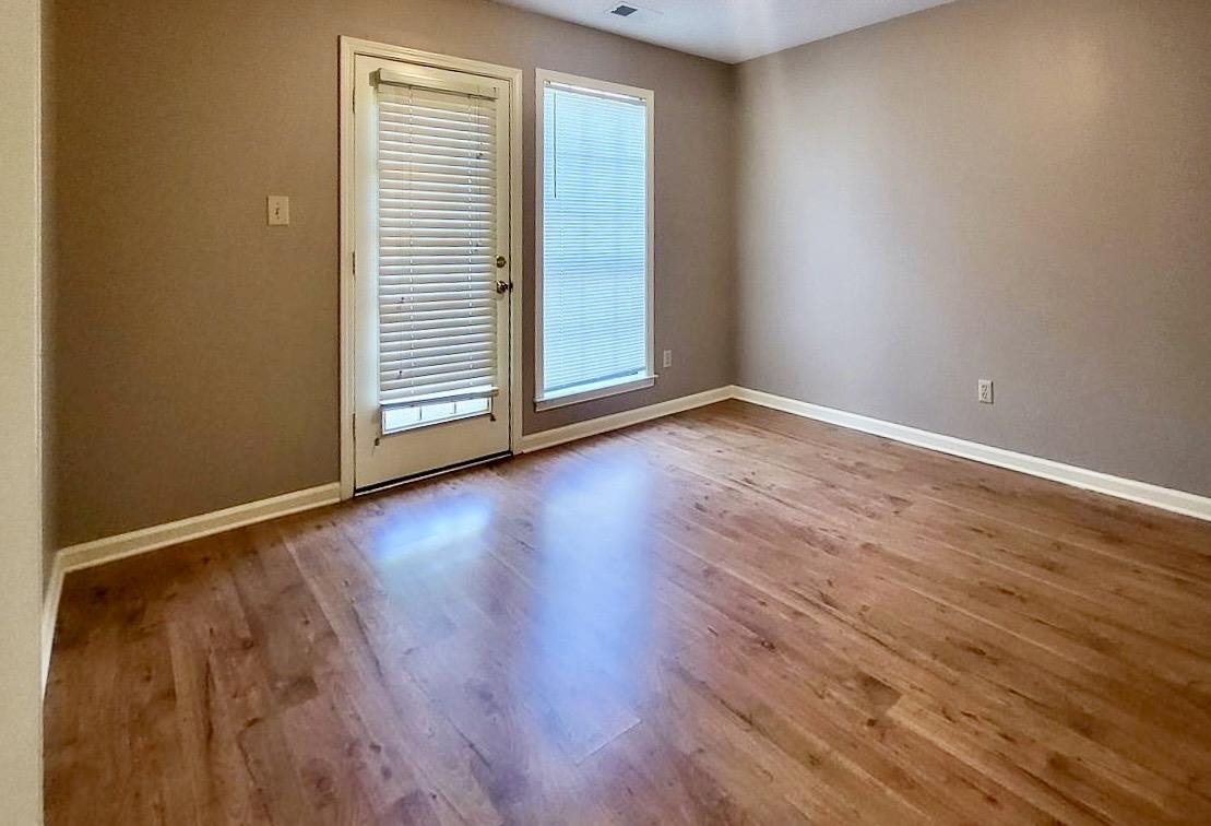 8326 Twin Rivers Drive Memphis, TN 38016 - Photo 11 of 21 Wood-finish flooring with a neutral wall color, featuring a glass-paneled door and an additional window with blinds
