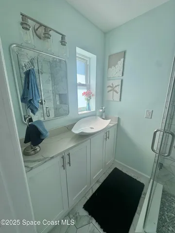 a bathroom with a sink a toilet a mirror and shower