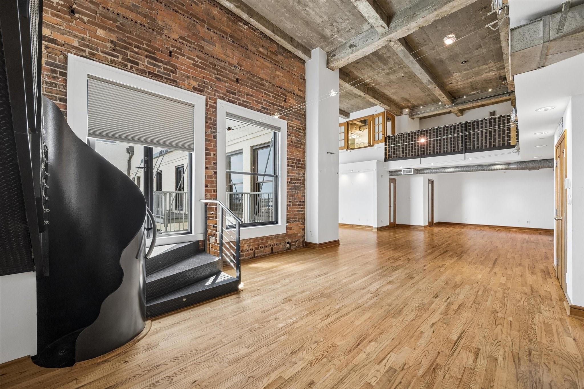 915 Franklin Street, Unit 9L Houston, TX 77002 - Photo 4 of 50 Bright loft with light wood floors, high ceilings, and a brick wall in the dining and living areas.