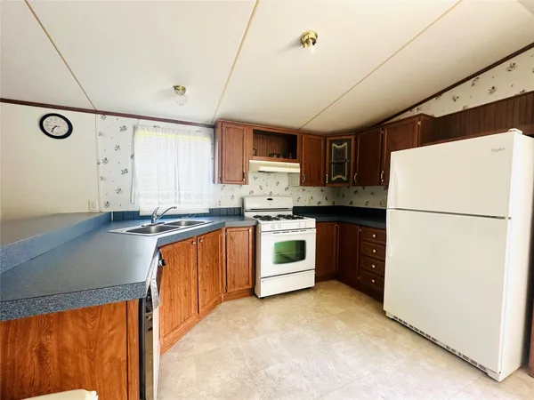 a kitchen with a refrigerator a stove top oven and white cabinets