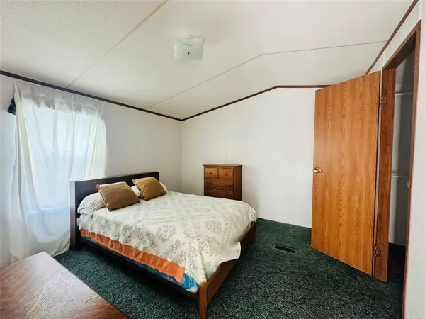 a bedroom with a bed lamp and a window