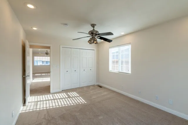 a very nice looking room with a ceiling fan and window