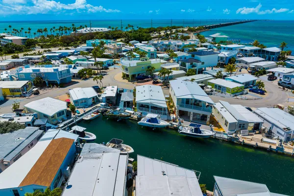 an aerial view of a city with lots of residential buildings ocean and mountain view in back
