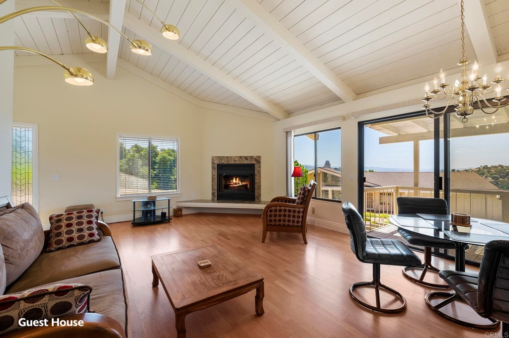 2627 Via Oeste Drive Fallbrook, CA 92028 - Photo 21 of 41 a living room with furniture a fireplace and a floor to ceiling window