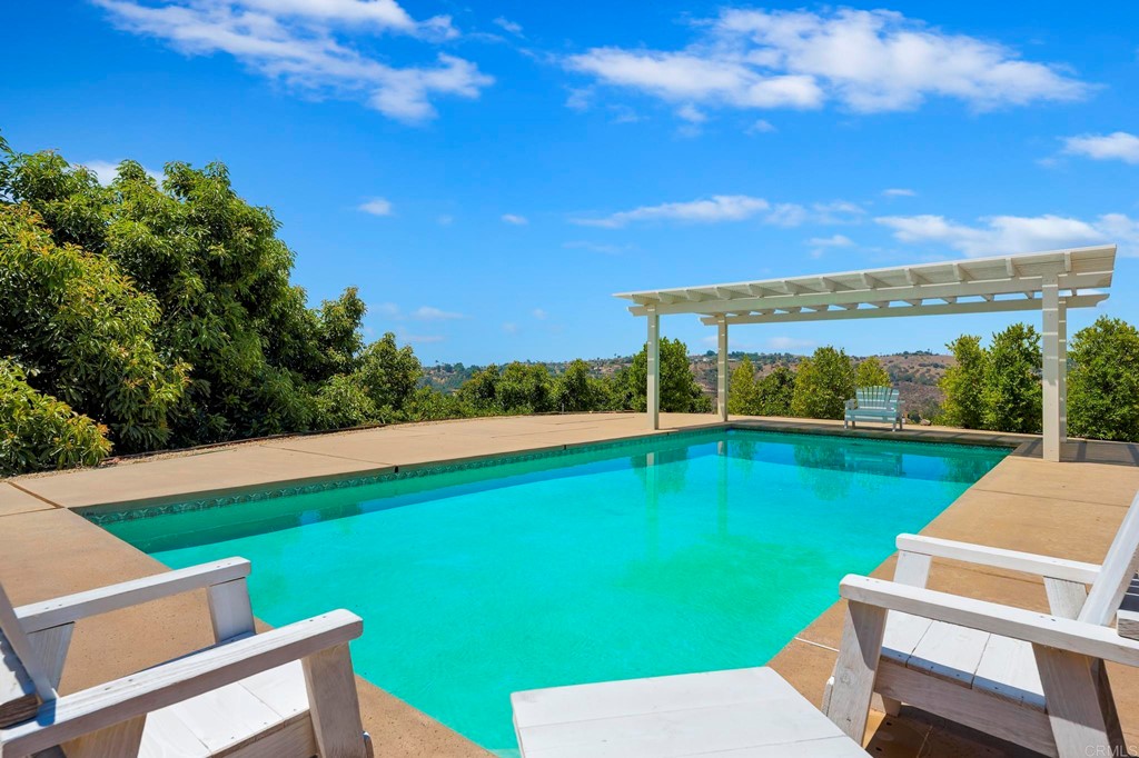 2627 Via Oeste Drive Fallbrook, CA 92028 - Photo 28 of 41 a view of a swimming pool with lawn chairs under an umbrella