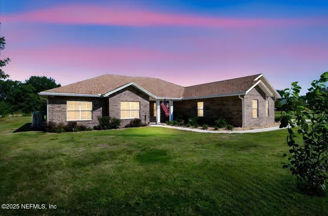 a front view of a house with a yard and trees