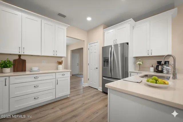 a kitchen with a refrigerator and a stove top oven