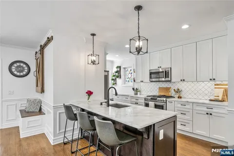 a kitchen with granite countertop white cabinets and stainless steel appliances