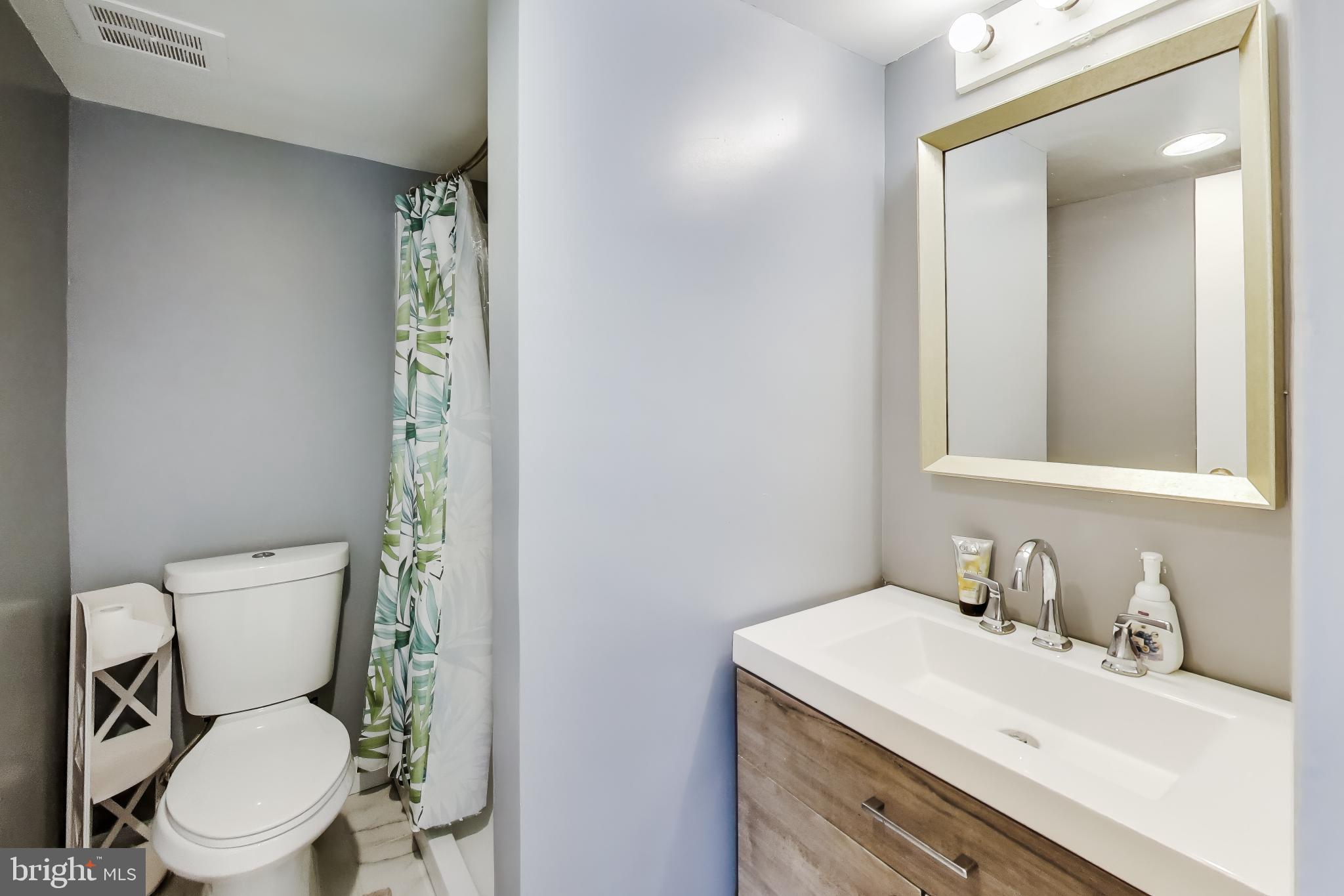 3206 Spartan Road, Unit 17 Olney, MD 20832 - Photo 14 of 28 a bathroom with a toilet sink vanity and mirror