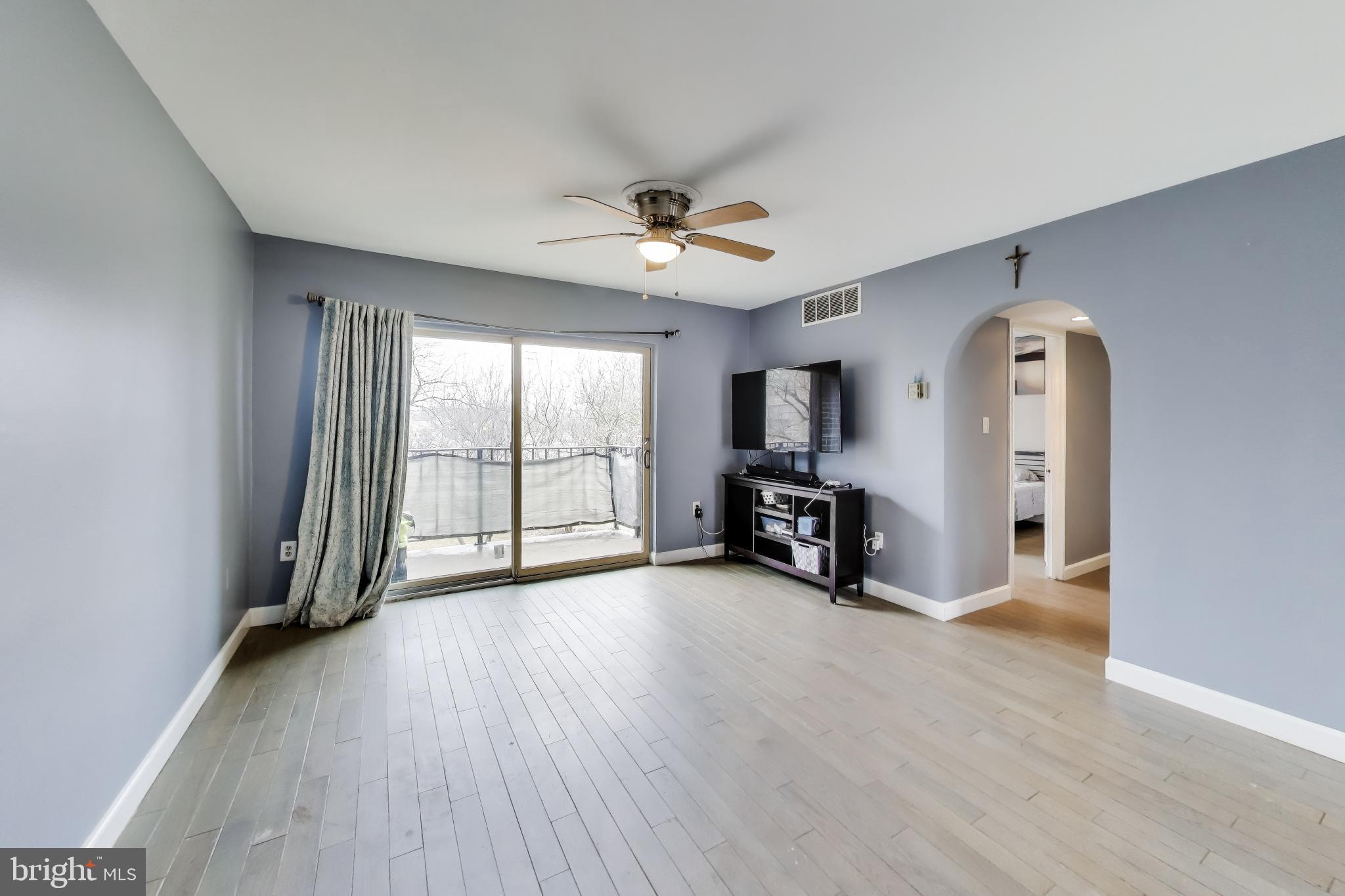 3206 Spartan Road, Unit 17 Olney, MD 20832 - Photo 4 of 28 an empty room with fireplace and windows