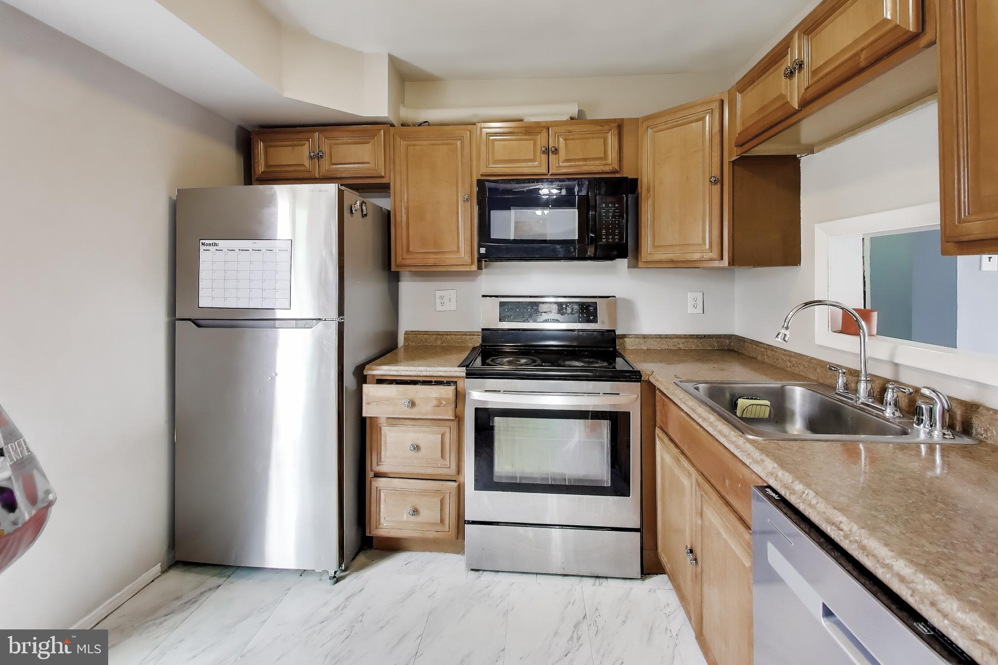 3206 Spartan Road, Unit 17 Olney, MD 20832 - Photo 9 of 28 a kitchen with stainless steel appliances granite countertop a refrigerator stove and microwave