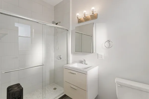 a bathroom with a sink a toilet and shower