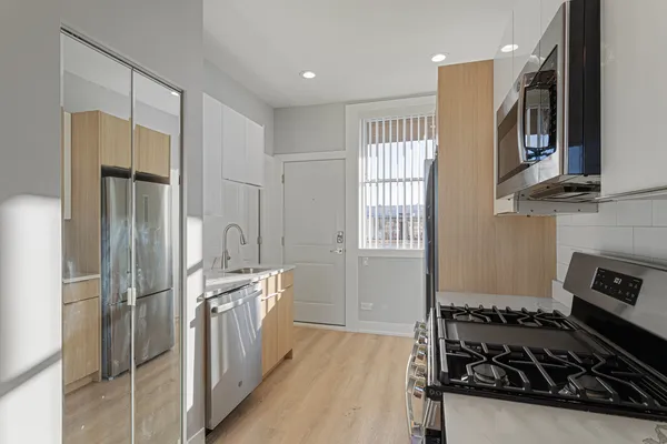 a kitchen with stainless steel appliances granite countertop a refrigerator and a stove
