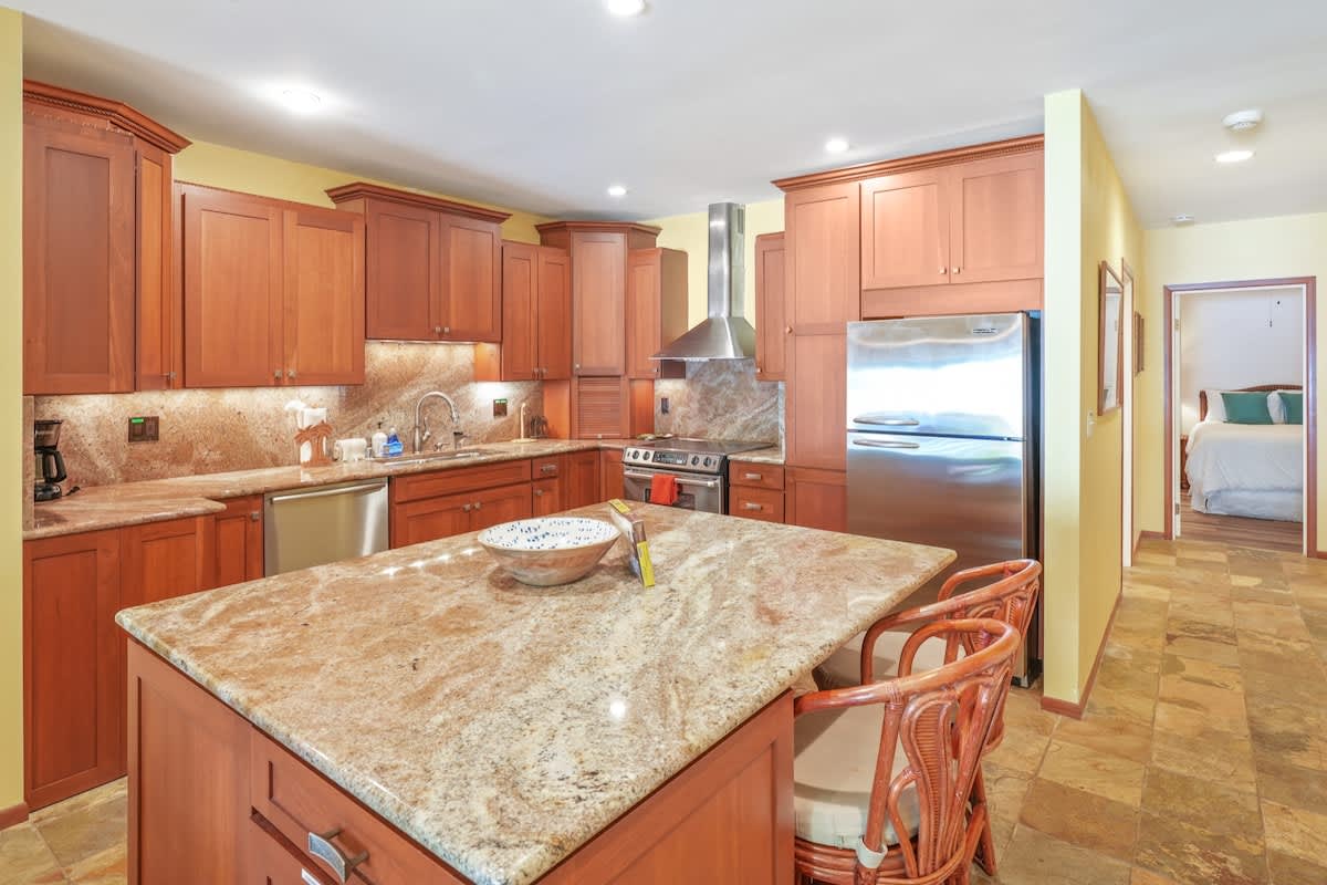 366 Papaloa Road, Unit 114 Kapaa, HI 96746 - Photo 12 of 23 a kitchen with kitchen island a sink table and chairs