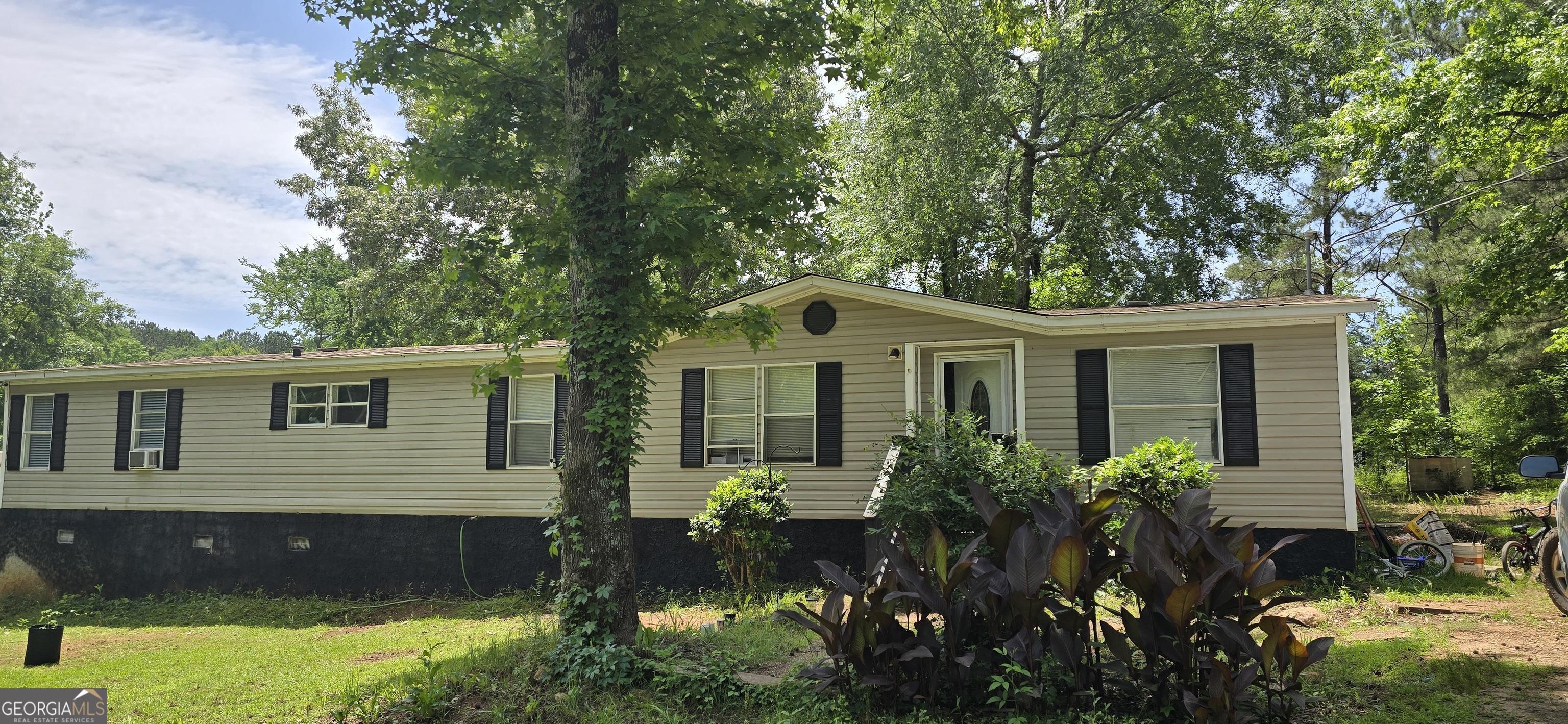 a front view of house with yard and trees around