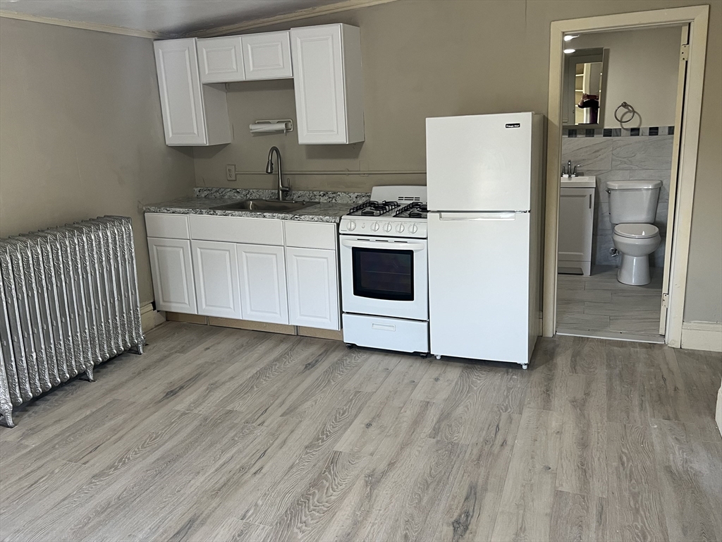 14 Monument Square, Unit 411 Boston, MA 02129 - Photo 1 of 7 a kitchen with a white cabinets and white appliances