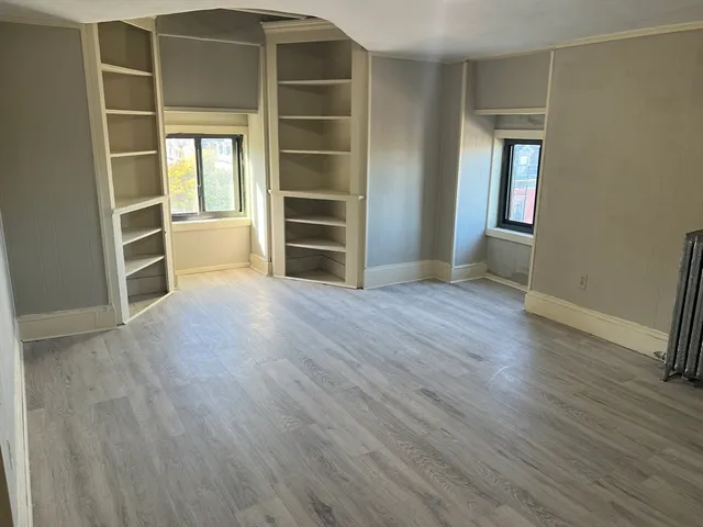 an empty room with wooden floor and closet