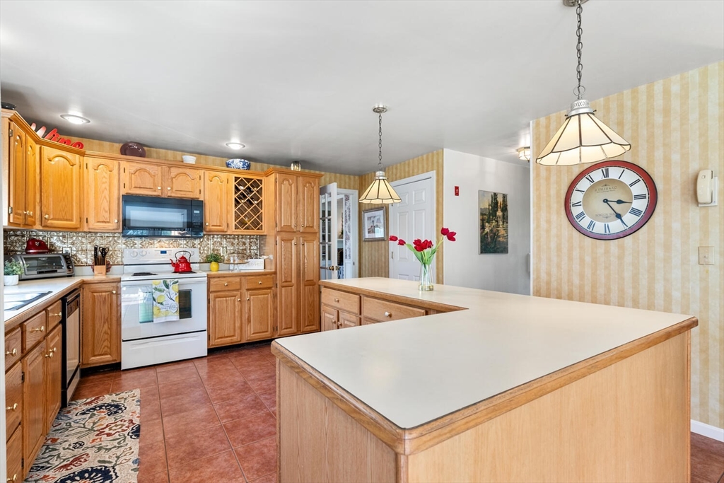 8 Oxford Road Gloucester, MA 01930 - Photo 14 of 35 a kitchen with a refrigerator a stove top oven a clock and a window
