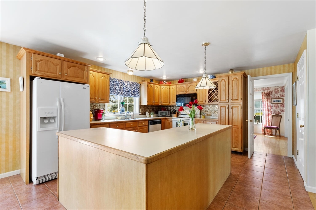 8 Oxford Road Gloucester, MA 01930 - Photo 15 of 35 a kitchen with stainless steel appliances a refrigerator a sink dishwasher a oven and a dining table with wooden floor