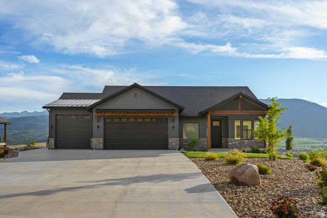 4499 North Seven Bridges Road, Unit 9 Eden, UT 84310 - Photo 61 of 65 Ranch-style residence featuring a gray exterior with stone accents, a dark shingle roof, and an attached three-car garage