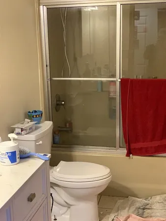 a bathroom with a sink a toilet and shower