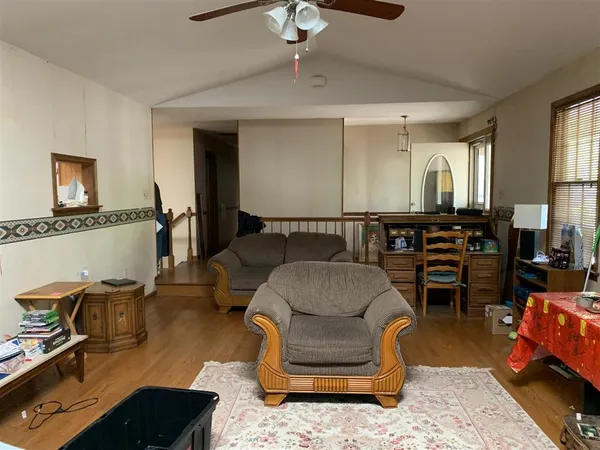 a living room with furniture a piano and wooden floor