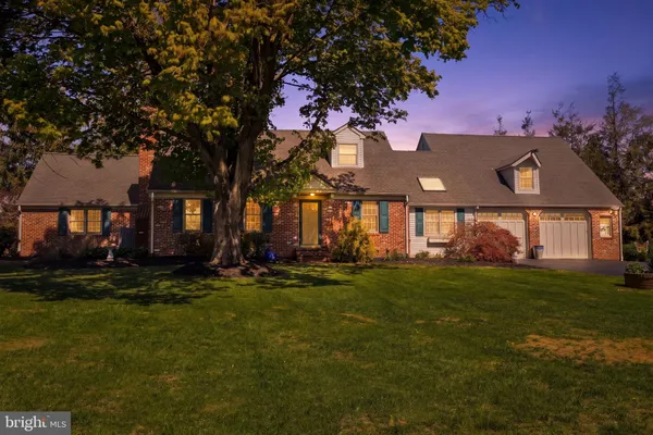 a view of a house with a big yard and large trees
