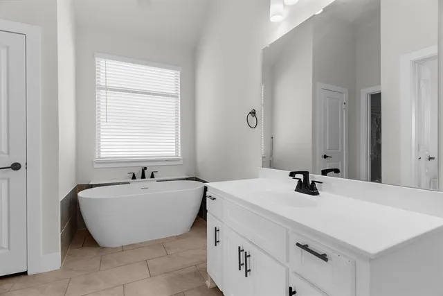 a bathroom with a tub sink and mirror