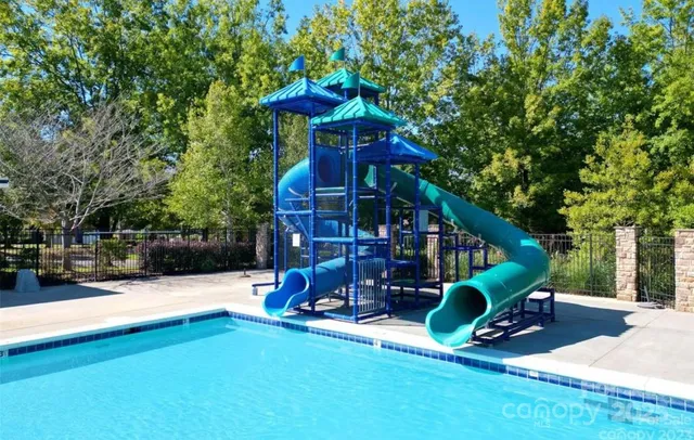 an aerial view of residential house with outdoor space and trees all around