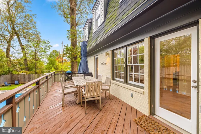 a balcony with wooden floor and outdoor seating