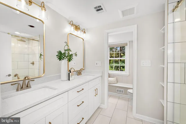 a bathroom with a granite countertop sink vanity mirror next to a window
