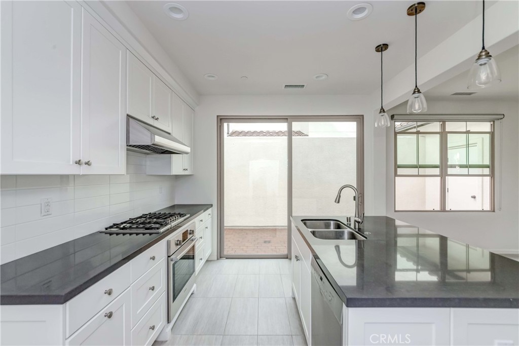 118 Walking Stick Irvine, CA 92618 - Photo 4 of 26 a kitchen with stainless steel appliances granite countertop a sink stove and refrigerator