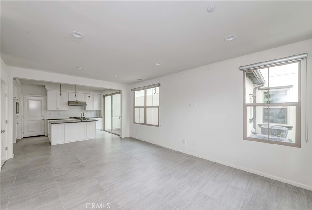 118 Walking Stick Irvine, CA 92618 - Photo 7 of 26 a large white kitchen with kitchen island a stove a sink and a large window