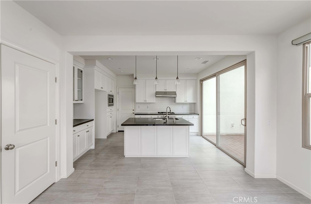 118 Walking Stick Irvine, CA 92618 - Photo 8 of 26 a large white kitchen with stainless steel appliances