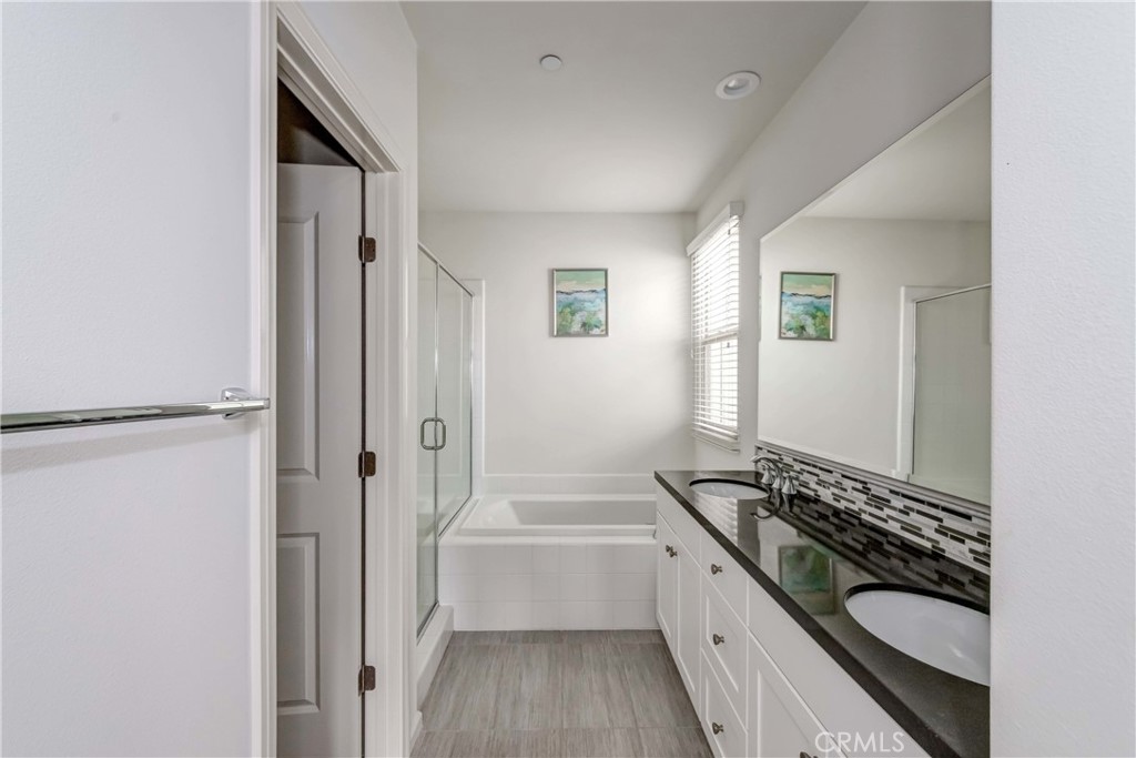 118 Walking Stick Irvine, CA 92618 - Photo 9 of 26 a bathroom with a granite countertop sink a mirror and a bathtub