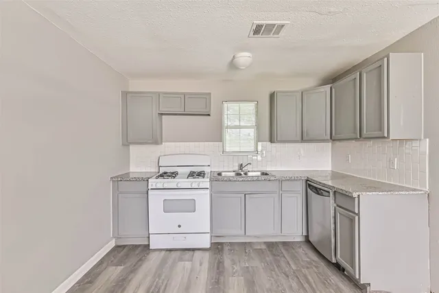 a kitchen with a stove sink and cabinets