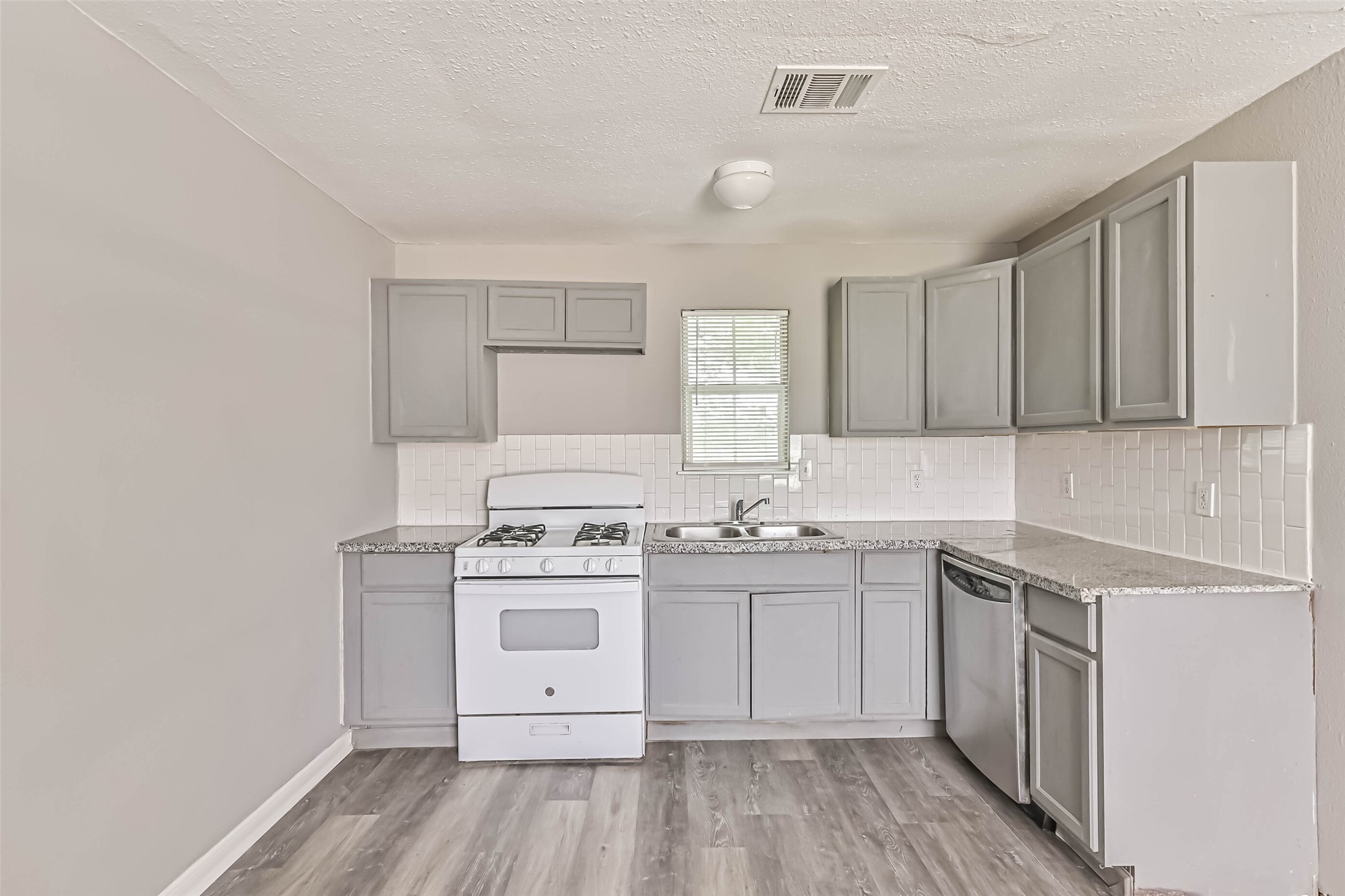 9839 Racine Street, Unit 1/2 Houston, TX 77029 - Photo 12 of 26 a kitchen with a stove sink and cabinets