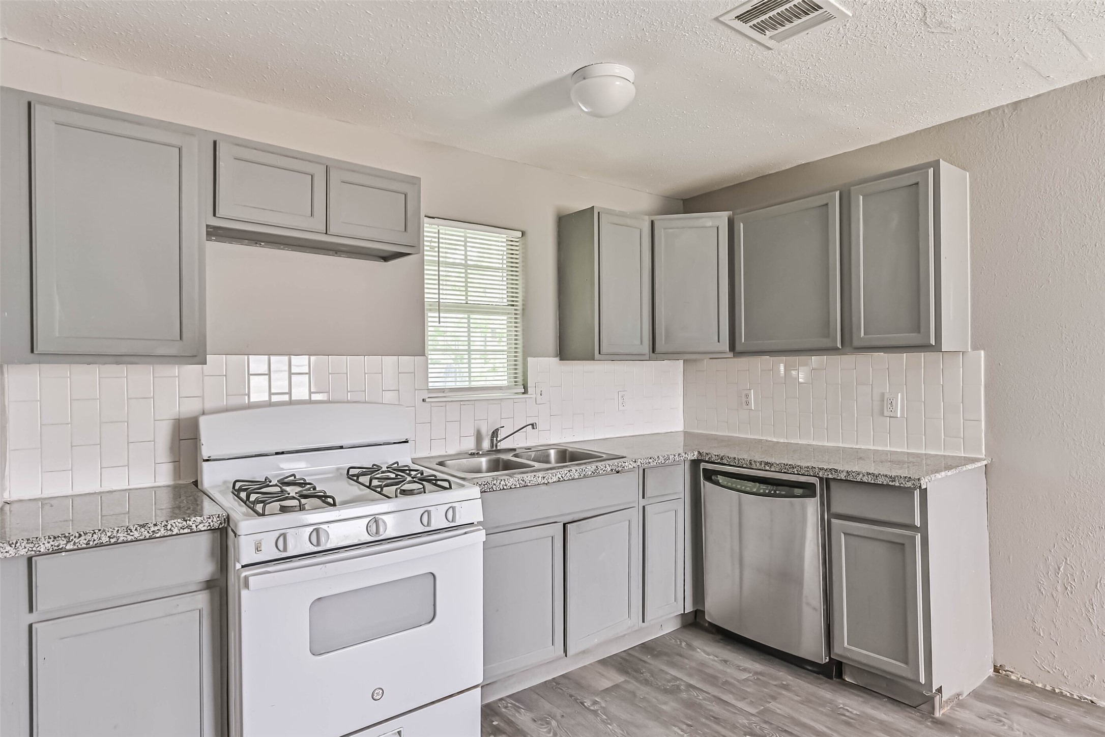 9839 Racine Street, Unit 1/2 Houston, TX 77029 - Photo 13 of 26 a kitchen with white cabinets sink and white appliances