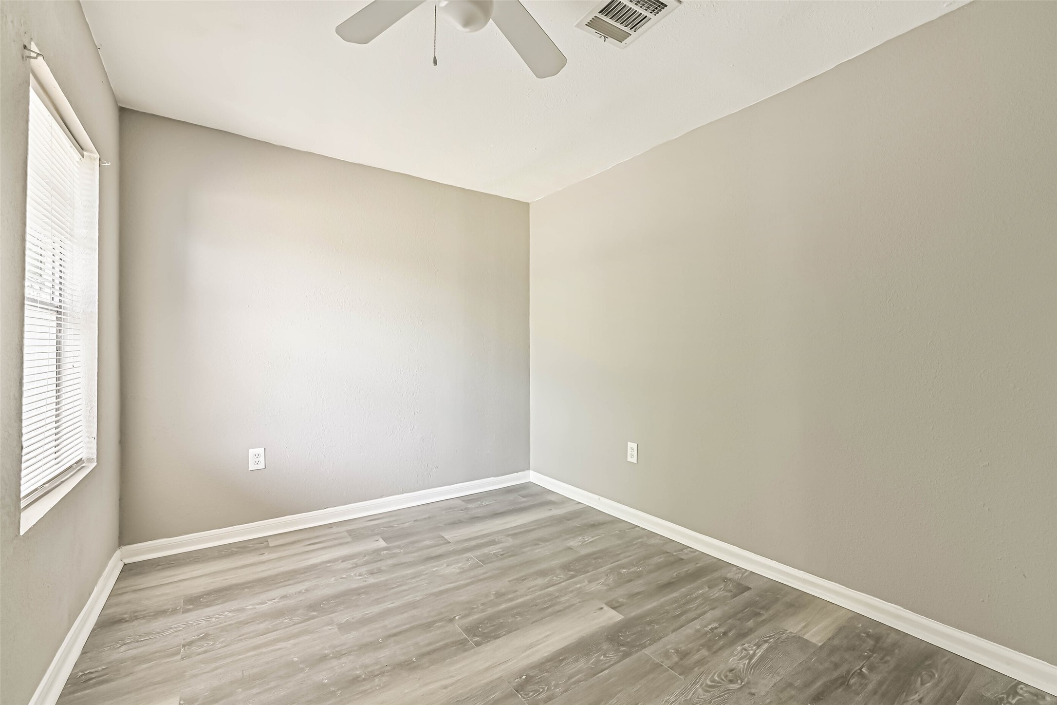 9839 Racine Street, Unit 1/2 Houston, TX 77029 - Photo 21 of 26 an empty room with wooden floor and windows