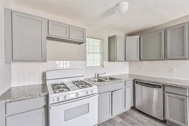 a kitchen with granite countertop white cabinets and white appliances