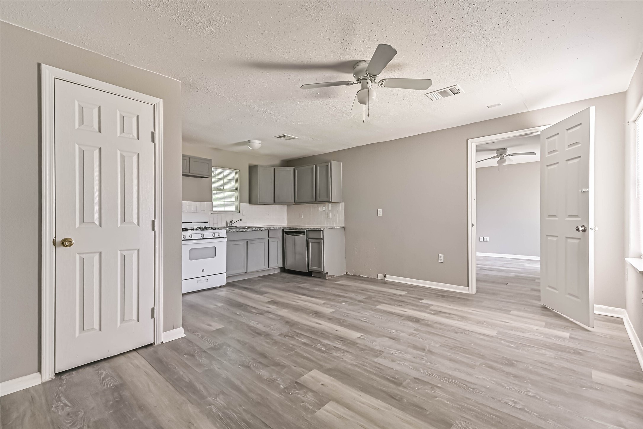 9839 Racine Street, Unit 1/2 Houston, TX 77029 - Photo 10 of 26 a view of a kitchen with wooden floor electronic appliances and cabinets