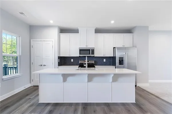 a view of kitchen with stainless steel appliances cabinets and a window