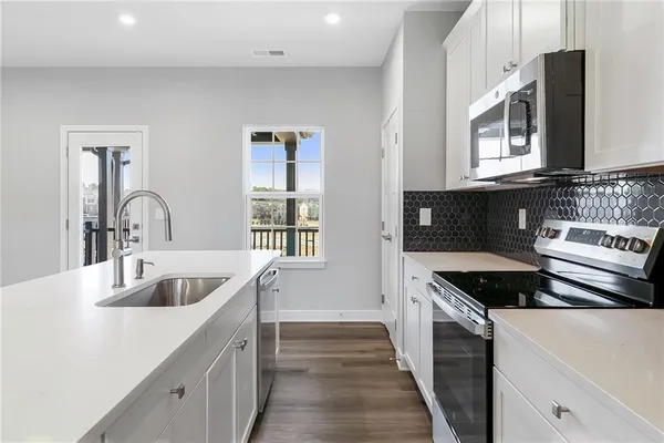 a kitchen with granite countertop a sink and a stove top oven