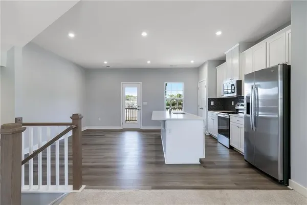 a view of kitchen with furniture and refrigerator