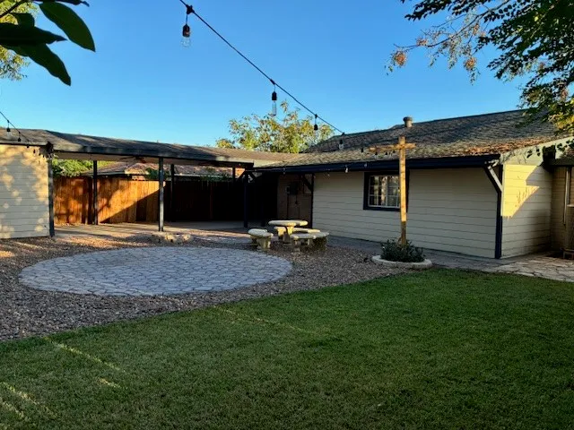 a backyard of a house with fountain table and chairs