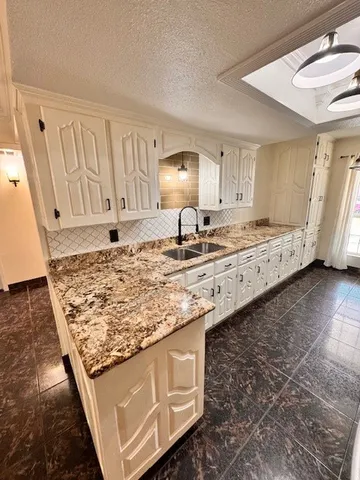 a kitchen with kitchen island granite countertop a sink and granite counter tops