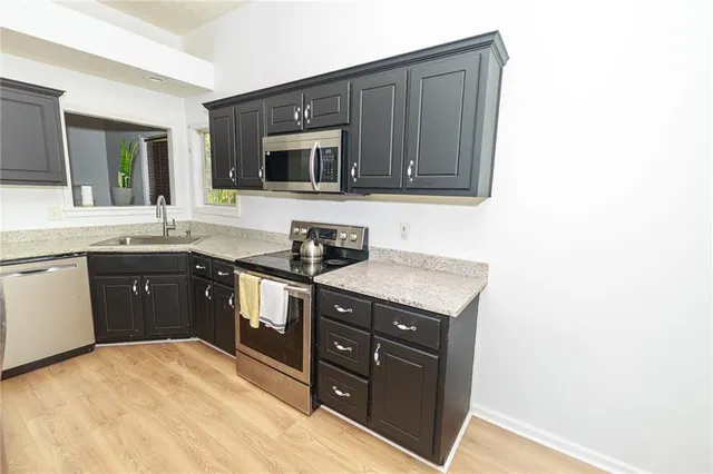 a kitchen with stainless steel appliances granite countertop a stove a sink and a microwave
