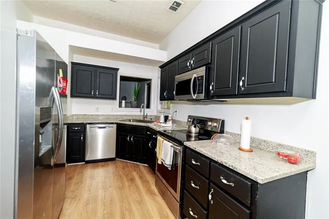 a kitchen with stainless steel appliances granite countertop a sink stove microwave and cabinets